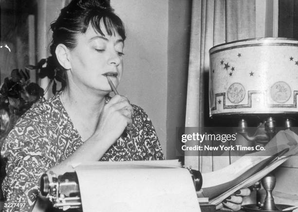 American writer Dorothy Parker reviews a draft copy of a manuscript at her home.