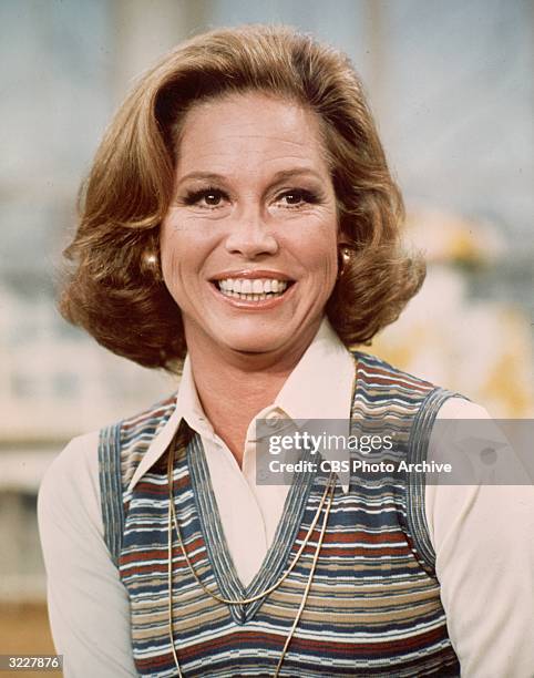 American actor Mary Tyler Moore smiling in a headshot still from the television series, 'The Mary Tyler Moore Show'. She is wearing a white blouse...