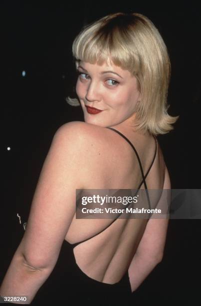 American actor Drew Barrymore smiles while looking over her shoulder in a backless black dress, New York City.