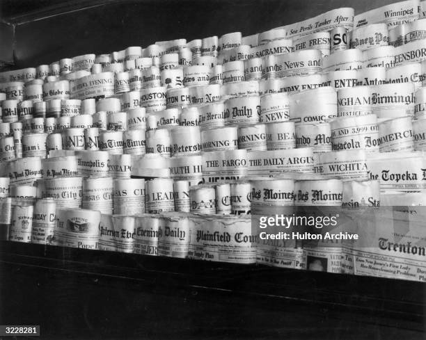 View of rows of newspapers from various American cities sitting in the racks of a newsstand, Times Square, New York City.