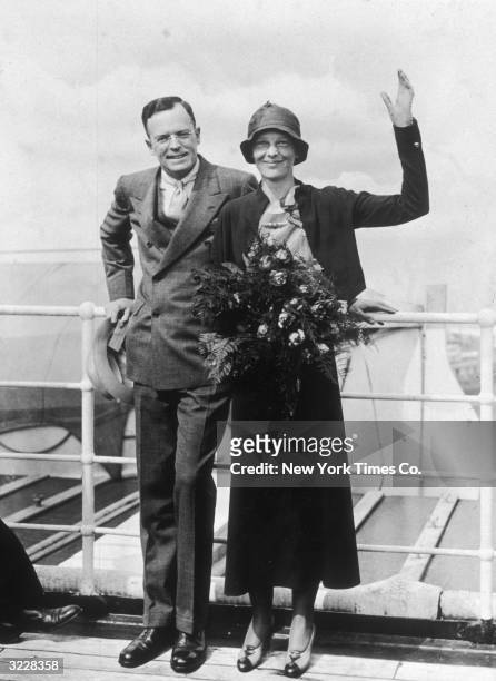 Full-length image of aviator Amelia Earhart and her husband, publisher George Palmer Putnam, waving as they return from Europe aboard the S.S. 'Ile...