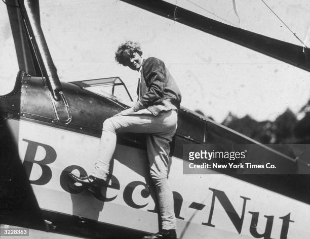 American aviator Amelia Earhart climbs into the cockpit of her airplane at Willow Grove, Pennsylvania, just before embarking on a trip to California.