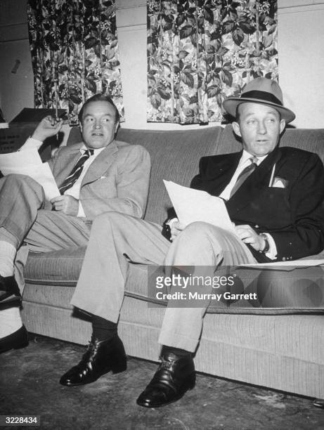 British-born actor and comedian Bob Hope sits while rehearsing for his radio show with American actor and singer Bing Crosby.