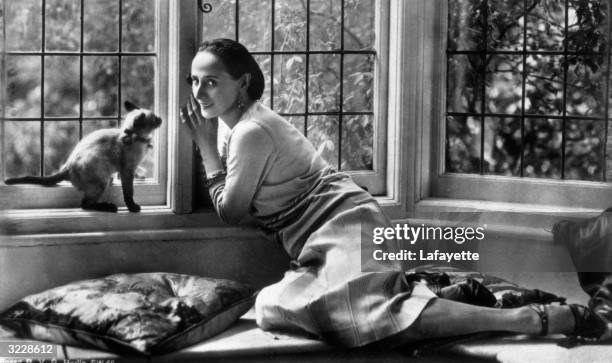 Russian ballet dancer Anna Pavlova relaxing at home with her pet cat.