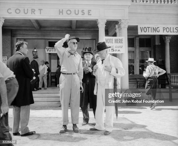 Director John Ford surrounded by costumed actors on the set of 'The Sun Shines Bright'. The actor in the white suit is Charles Winninger , who plays...