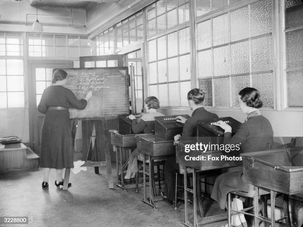 Class learning how to key telephone calls to automatic exchanges at Telephone House in Salford. More operators are needed to cope with increased...