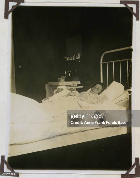 Edith Frank, the mother of Anne Frank, lies in bed holding her newborn daughter, Margot, Frankfurt am Main, Germany. Taken from the photo album of...
