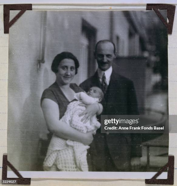 Portrait of Edith and Otto Frank, the parents of Anne Frank, with their infant daughter, Margot, outdoors taken from Margot Frank's photo album,...