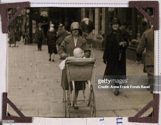 Edith Frank, the mother of Anne Frank, pushes her daughter Margot in a stroller as her mother, Mrs Hollander-Stern walks along side them, Aachen,...