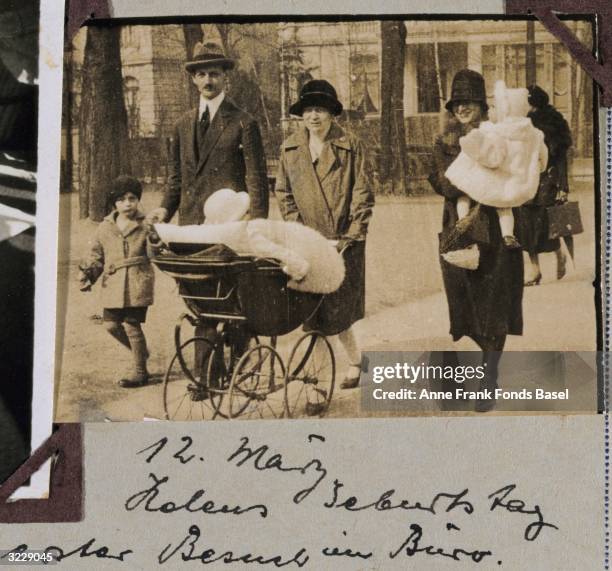 Otto Frank, the father of Anne Frank, takes a walk holding his nephew Elias' hand while an unidentified woman pushes Margot Frank in a stroller,...