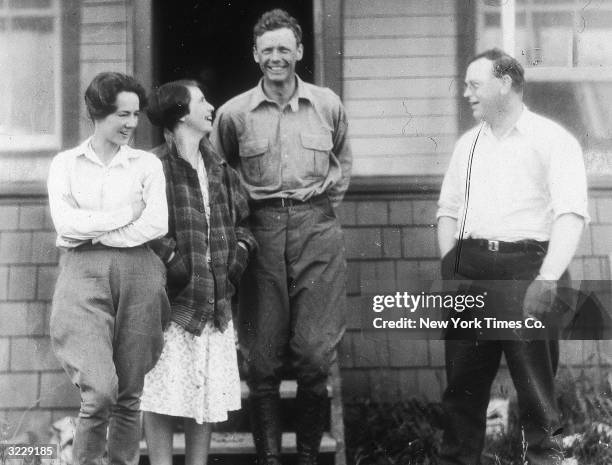 Anne Morrow Lindbergh and her husband, American aviator Charles Lindbergh , stand with a man and a woman outdoors on the steps of a home. After their...