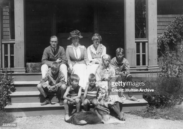 Portrait of American politician Franklin Delano Roosevelt sitting with his family on the steps of a porch. Top step, L-R: Franklin D. Roosevelt; his...