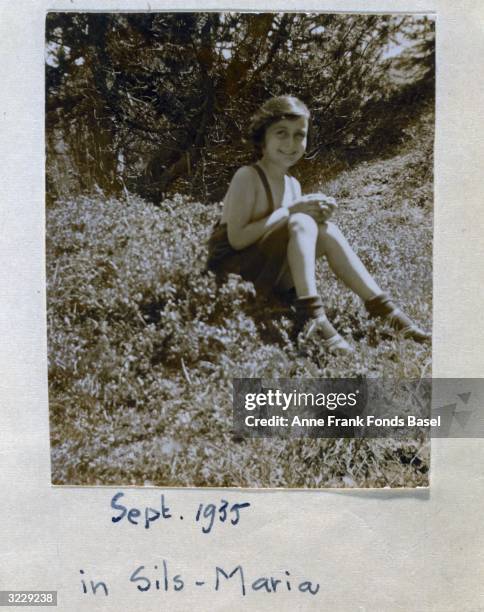 Portrait of Anne Frank sitting in a field near the Villa Laret of Olga Spitzer, Sills-Maria, Switzerland. Taken from her photo album.