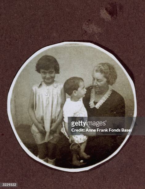 Portrait of Margot Frank, standing next to an elderly woman with Anne Frank on her lap. A page from Margot Frank's photo album.