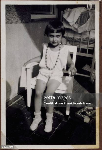 Portrait of Margot Frank, the older sister of Anne Frank, sitting in a chair wearing a beaded necklace, Aachen, Germany. From Margot Frank's photo...