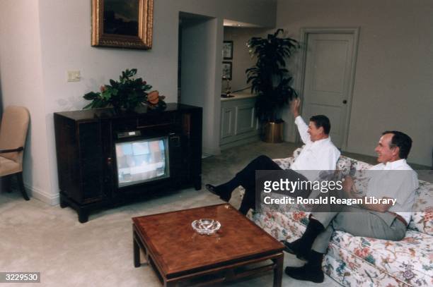 President Ronald Reagan sits on a sofa with Vice President George Bush watching First Lady Nancy Reagan's national televised speech at the GOP...