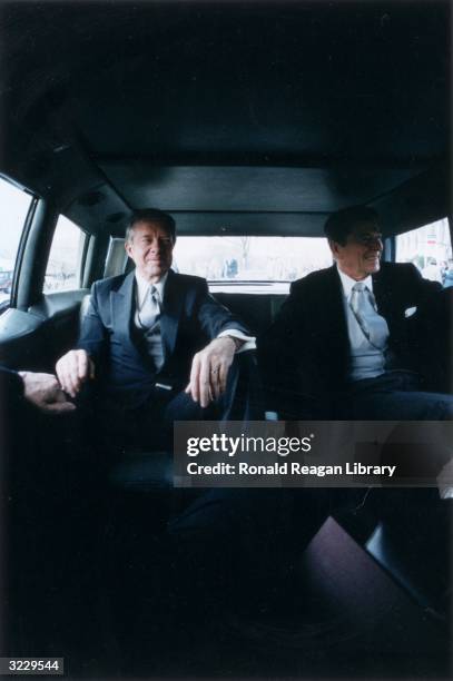 Outgoing US President Jimmy Carter sits with president-elect Ronald Reagan in the back of a limousine en route to Reagan's Presidential Inauguration...
