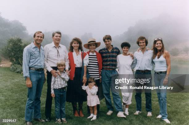 President Ronald Reagan and First Lady Nancy Reagan pose outdoors with their family at Nancy's birthday party, Rancho Del Cielo, California. L-R:...