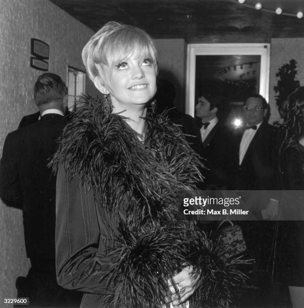 American actor Goldie Hawn poses in a grosgrain jacket trimmed with ostrich plumes at an annual Thalian Ball, California.
