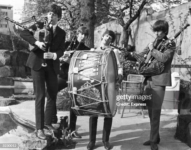 The British rock group The Beatles perform on bagpipes and marching drum outdoors to promote their concerts in the Scottish cities of Glasgow and...