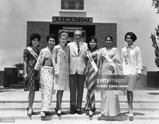 American animator and producer Walt Disney poses outside the Animation Building at Disney studios with the Miss Universe Girls, Hollywood,...