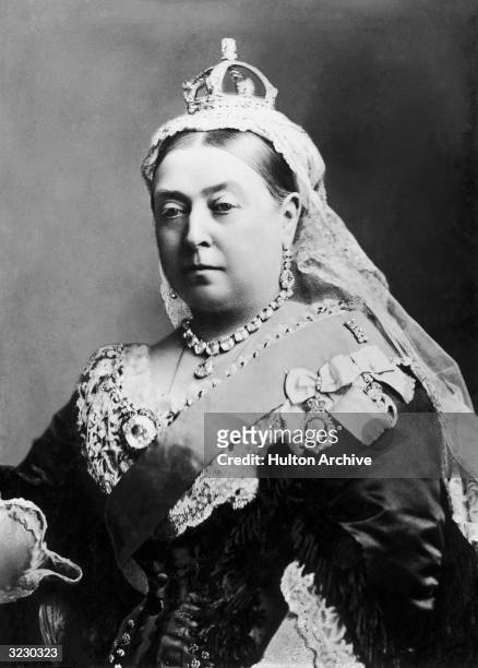 Portrait of Queen Victoria in the fiftieth year of her reign. She wears her crown and a diamond necklace and earrings.