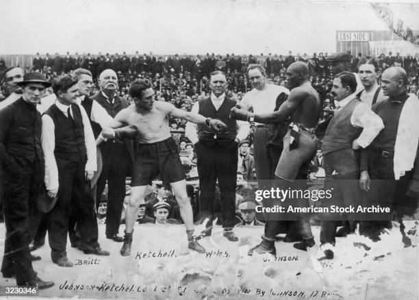 American boxers Stanley Ketchell and Jack Johnson touch gloves while squaring off in the boxing ring before their fight, San Francisco, California....