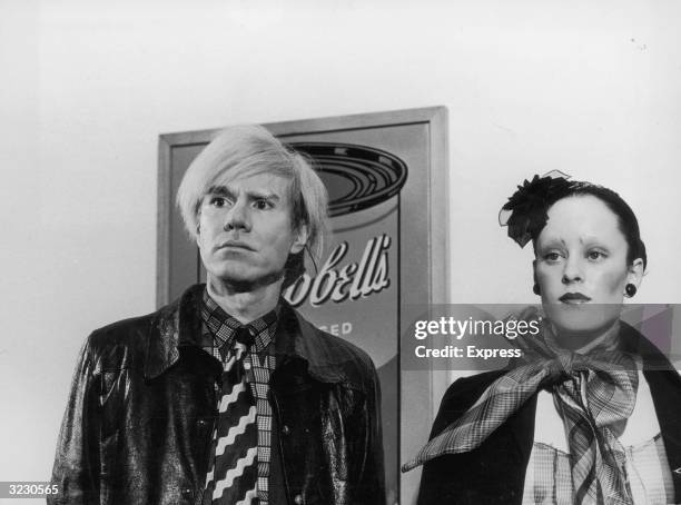 American Pop artist Andy Warhol stands next to actress Jane Forth, star of his new film 'Trash,' in front of his famous Campbell's Soup painting, in...