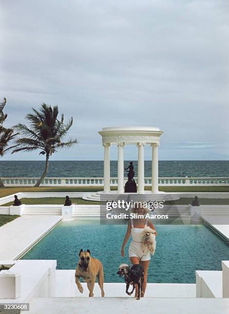 Premium Rates Apply. Circa 1955: Mrs F C Winston Guest with her dogs in front of the Grecian temple pool on her ocean-front estate, Villa Artemis,...