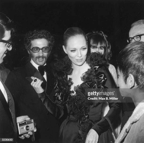 American actor Faye Dunaway speaks to a group of people while standing in front of director Jerry Shatsberg at the 41st Annual Academy Awards, Santa...