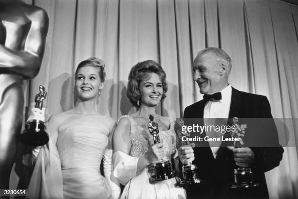 American actors Carol Lynley and Donna Reed and Fred Metzger hold Oscar statuettes as presenters, backstage at the Academy Awards, Santa Monica,...