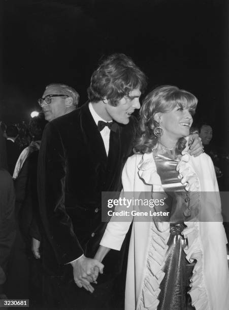 British actor Julie Christie smiles while holding hands with her date, Don Bessant, at the Academy Awards, Santa Monica, California. Christie won the...