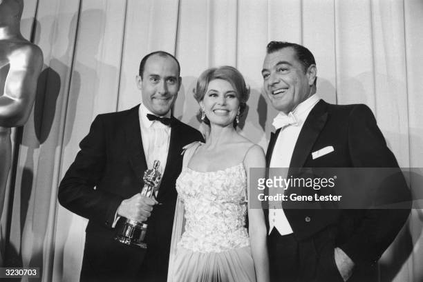 American composer Henry Mancini, American dancer Cyd Charisse, and American actor Tony Martin pose backstage at the Academy Awards, Santa Monica,...