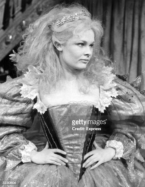 British actor Judi Dench stands with her hands on her hips, in costume as Titania for a stage production of William Shakespeare's play 'A Midsummer...