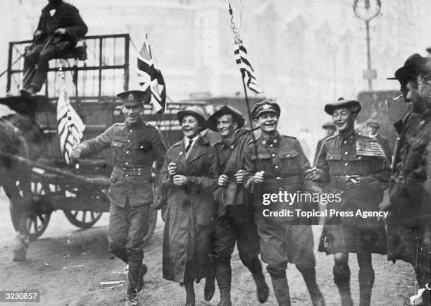 Group of soldiers, including a Scot, an Australian and a member of the WAAC, running down the Strand in London on Armistice Day.