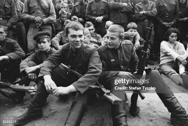 Armed Soviet troops watch the entertainment provided by the Red Army Ensemble at their encampment in a Prague park during their country's invasion of...