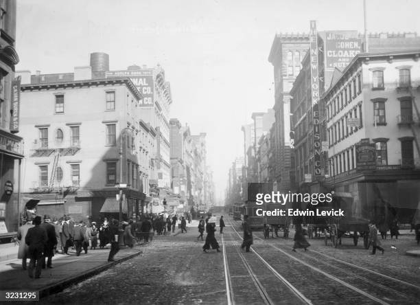 View of Broadway, looking north from Canal Street, New York City. Street cars and horse-drawn carriages provide transportation.