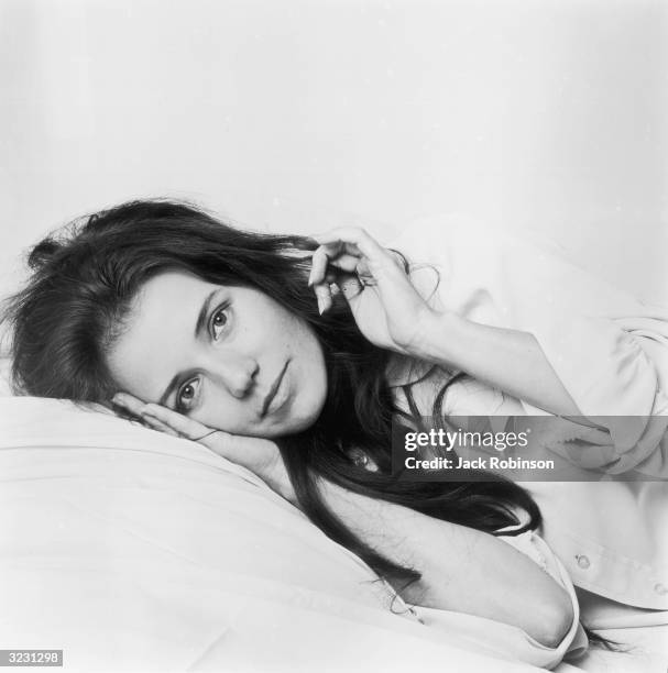 Studio portrait of American comedian and actor Trish Van Devere laying her head on a pillow.