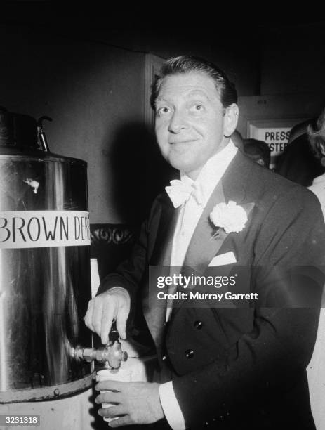 British composer and conductor David Rose pours himself a cup of coffee backstage at the Academy Awards, Los Angeles, California. The coffee is...