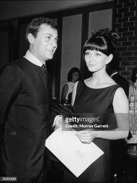 American actor Tony Curtis and his wife, Austrian actor Christine Kaufmann, smile while holding hands at the premiere of director Tony Richardson's...