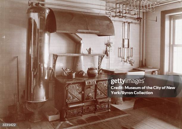 Cast iron stove and a water tank in the American Victorian-style kitchen of the home of the Hon. And Mrs. Theodore Sutro, 320 West 102nd Street, New...