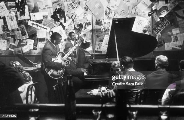 American jazz guitarist Wes Montgomery performs with his brothers Monk and Buddy in the Montgomery Brothers trio at the Five Spot nightclub on the...