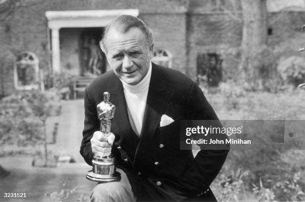 English actor John Mills holding the Oscar which he won for his role in the David Lean film 'Ryan's Daughter'.