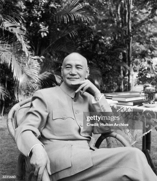 Portrait of exiled Chinese general and politician Chiang Kai-Shek sitting at a table in the garden of his home in Taipei, Taiwan. He wears a wearing...