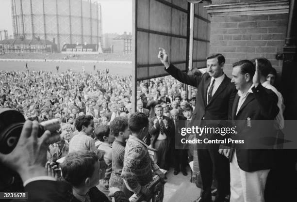 England captain, , Colin Cowdrey and his Australian counterpart Bill Lawry acknowledge the cheers of the crowd after England won the 5th and final...