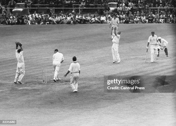 England captain Peter May looks on at his stumps in disbelief as he is bowled by Richie Benaud during England's disastrous second innings in the 4th...