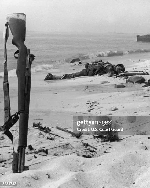 Rifle marks the spot where a US Marine lies dead on the beach at Parry Island, Eniwetok Atoll in the South Pacific, World War II.