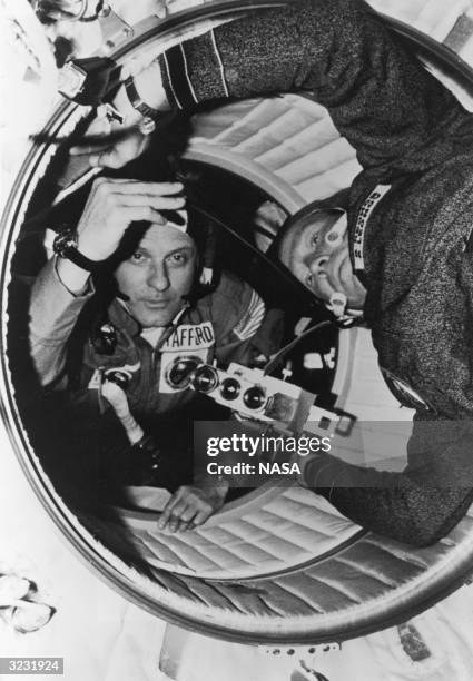 American astronaut Thomas P Stafford and Soviet cosmonaut Aleksey A Leonov move through the hatchway between the Apollo's docking module and the...