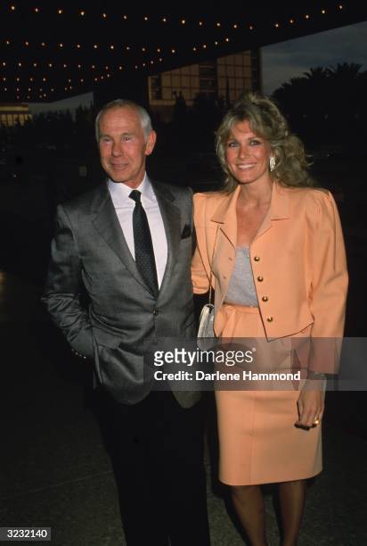 American talk show host Johnny Carson standing with his fourth wife, Alexis, under a theater marquee, at the opening of the musical 'Les Miserables,'...