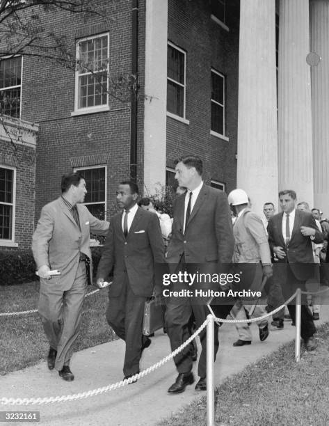 American civil rights activist James Meredith and attorney Joan Doar are escorted by Federal Marshals as they enter the all-white University of...